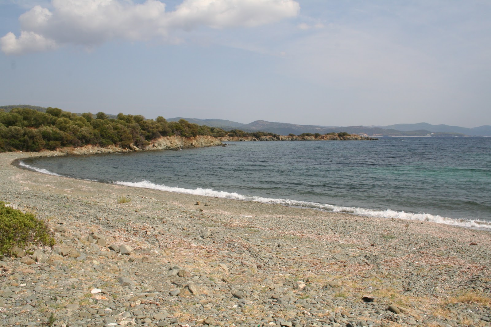 Foto av Diaporti beach II med musta hiekka ja kivi yta