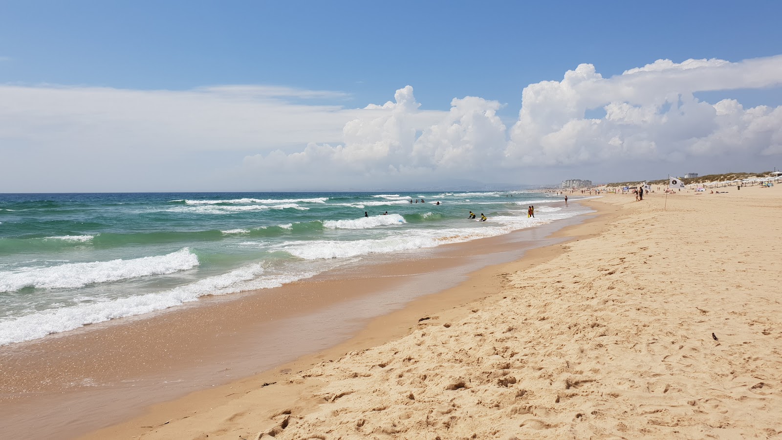 Foto av Praia Riviera med lång rak strand