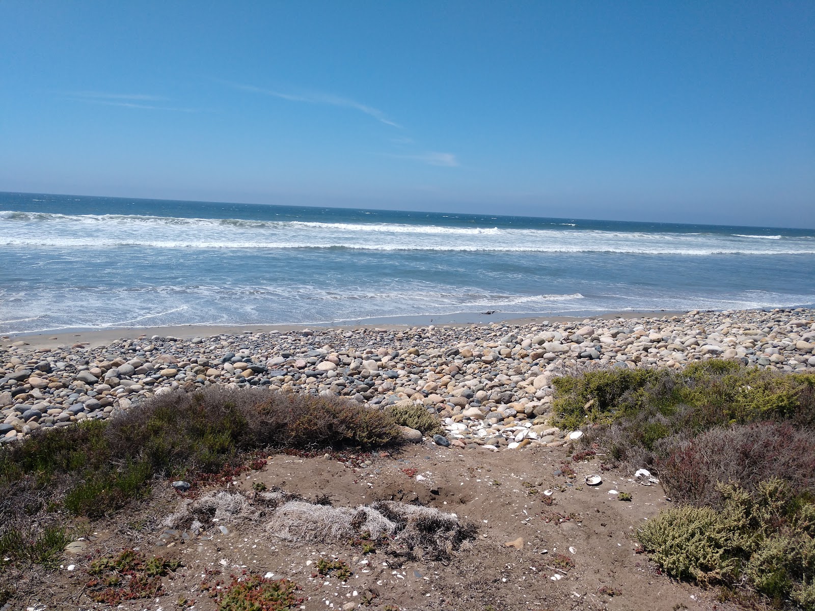 Valokuva Playa El Socorritoista. pinnalla musta hiekka ja kivi:n kanssa
