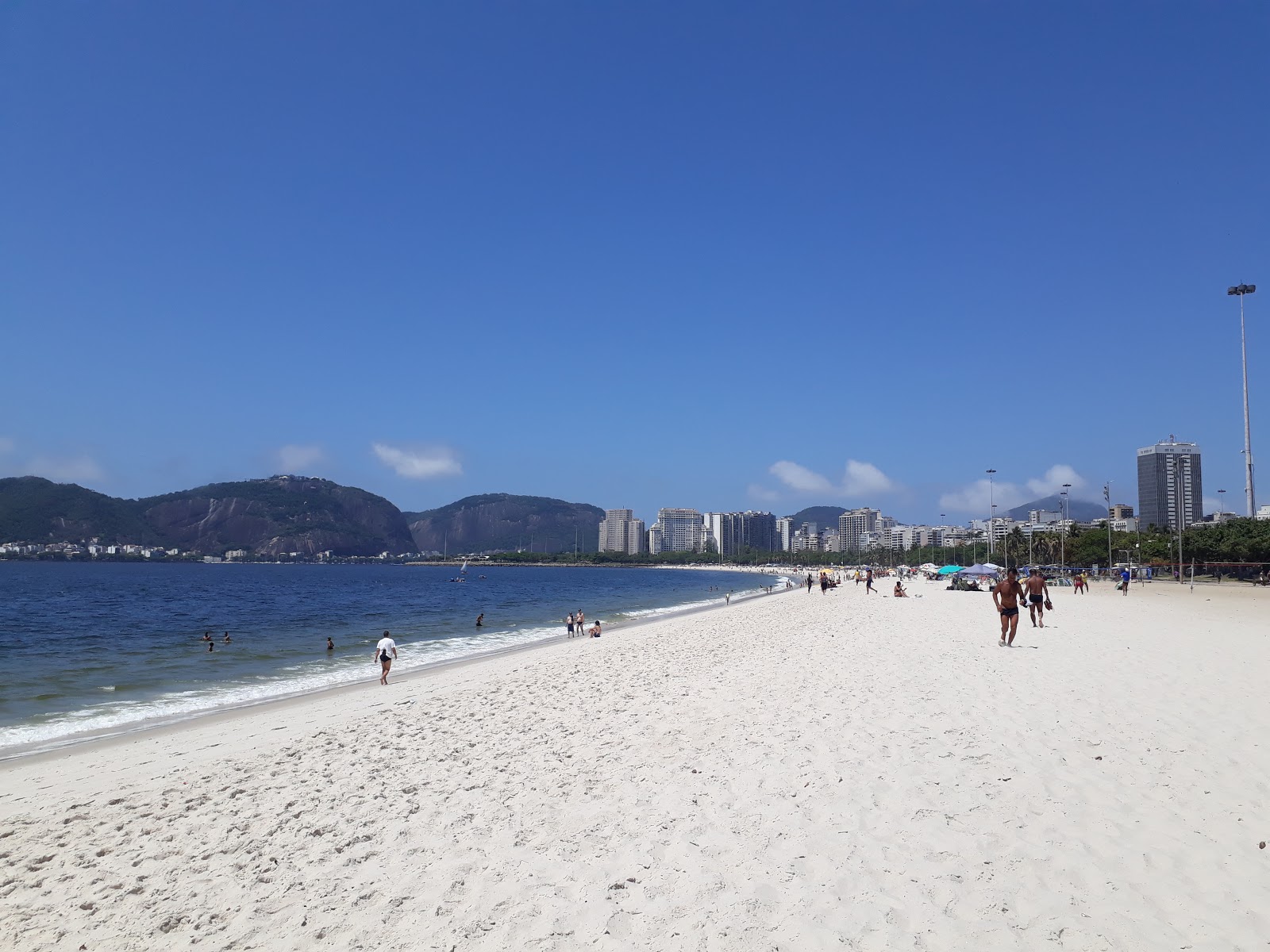 Foto di Praia do Flamengo con una superficie del sabbia beige fine