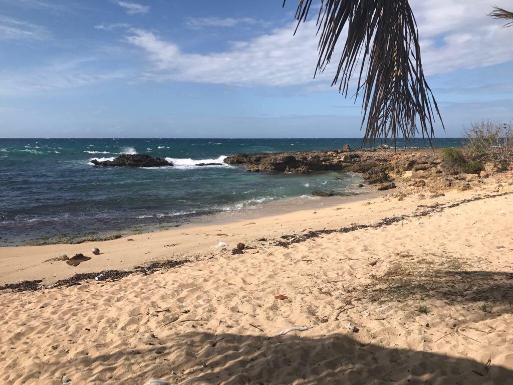 Foto van Camarioca beach met beige zand en stenen oppervlakte