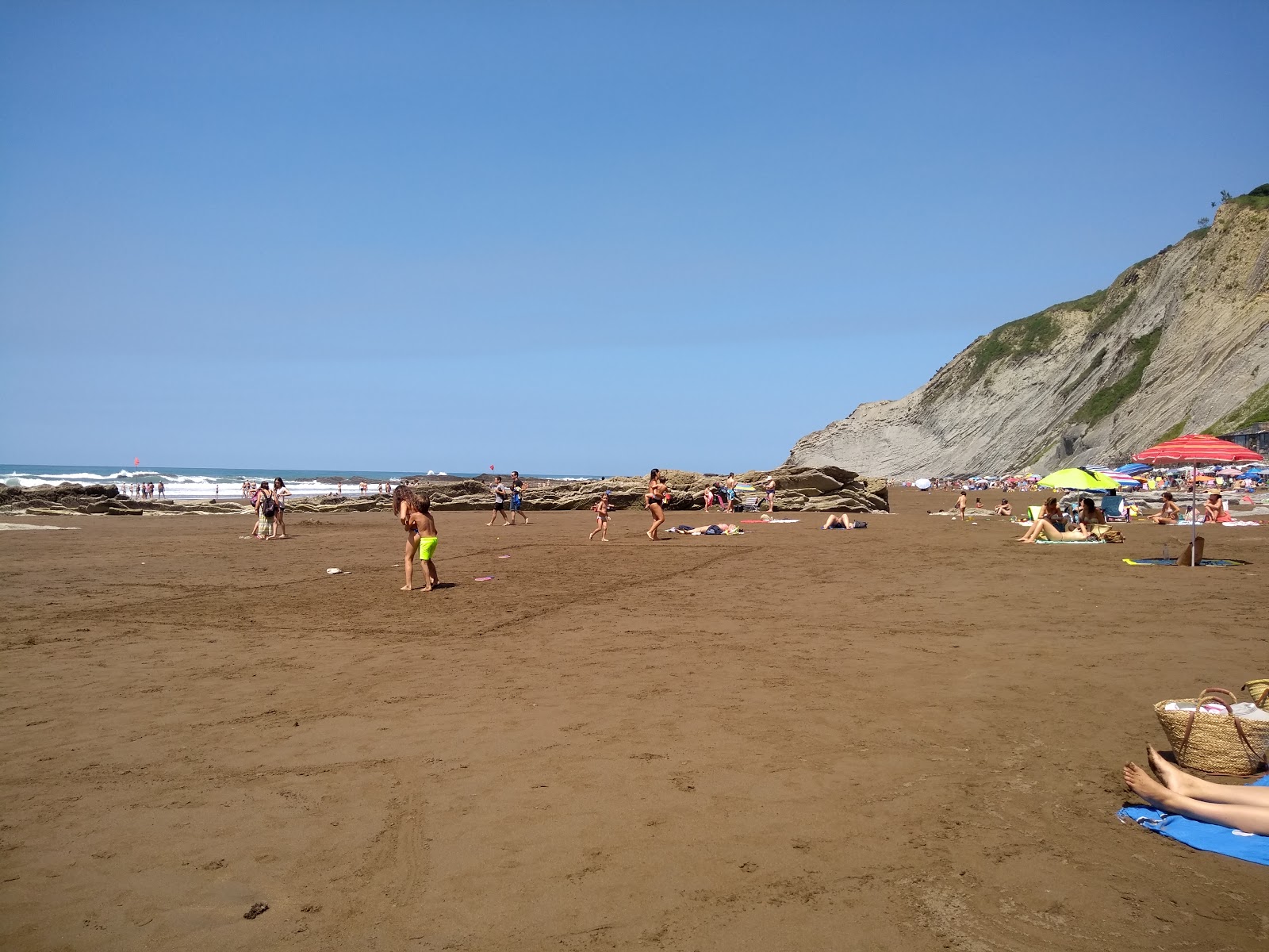 Foto av Playa de Itzurun omgiven av klippor