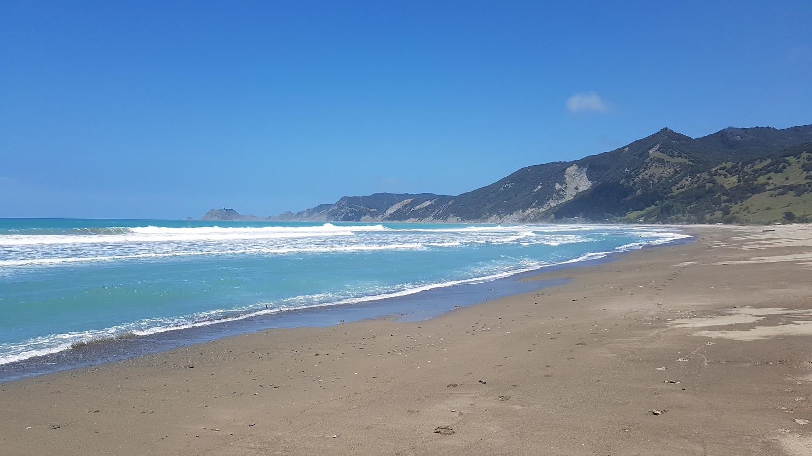 Photo of Tokomaru Beach with turquoise pure water surface