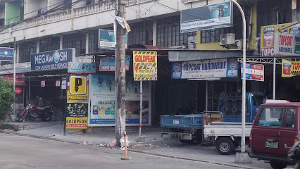 Street with small businesses, scooters, and parked vehicles. Signs for a laundromat and hardware store are visible.