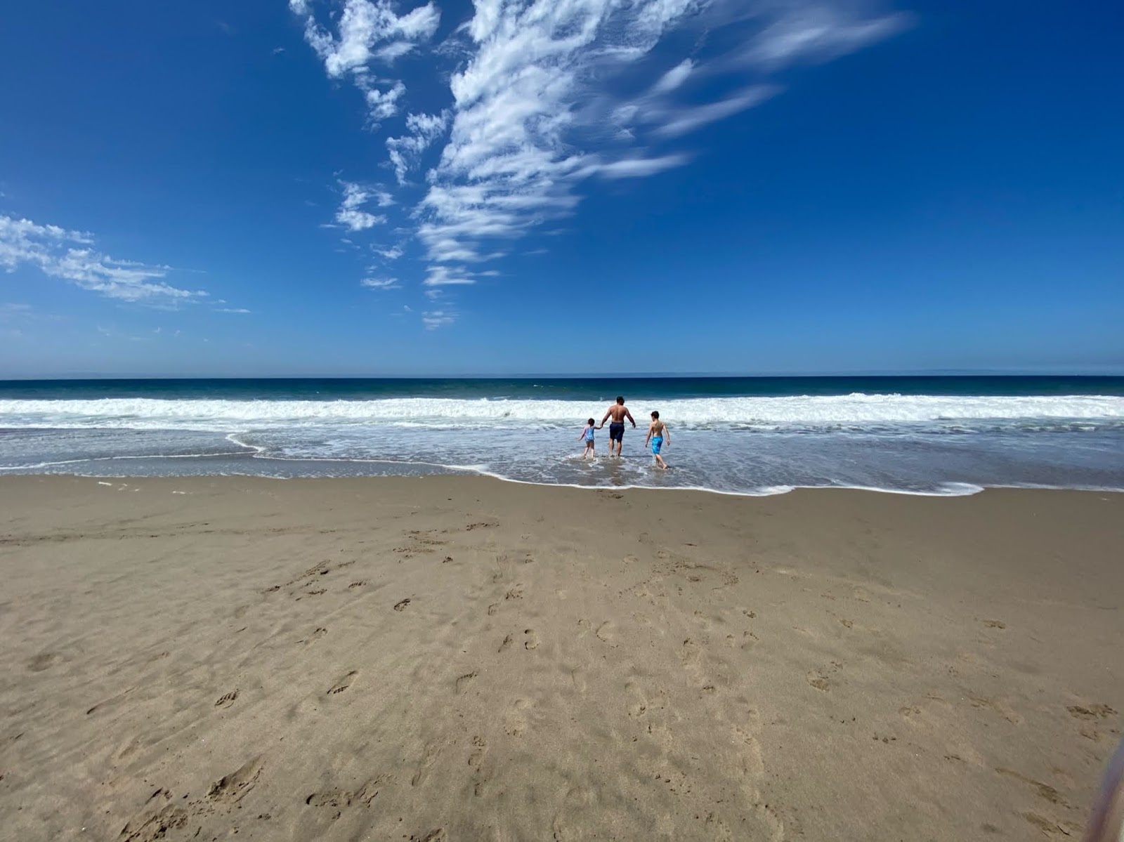 Foto von Zuma Beach von Klippen umgeben