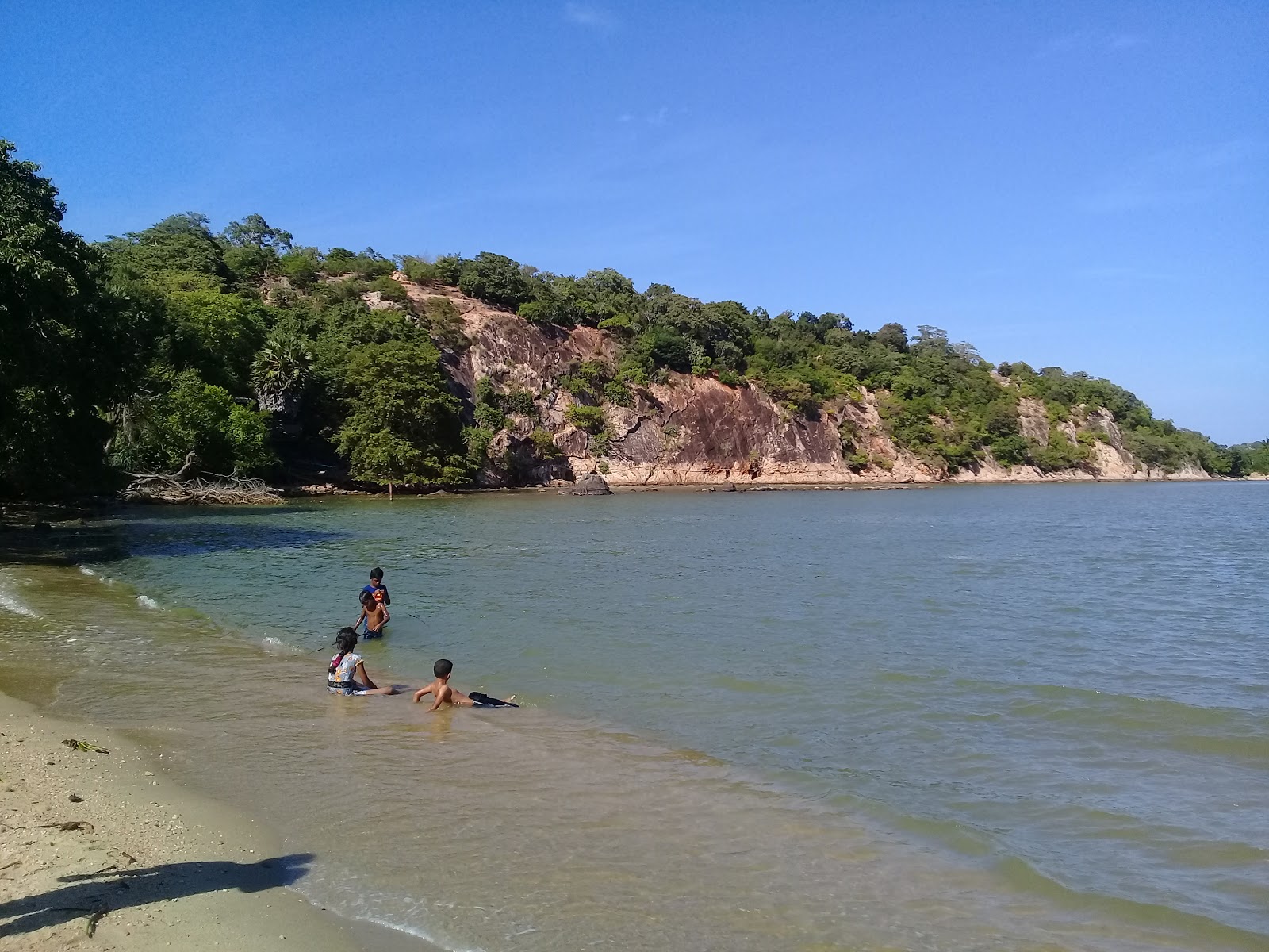 Foto av Marble Beach omgiven av klippor