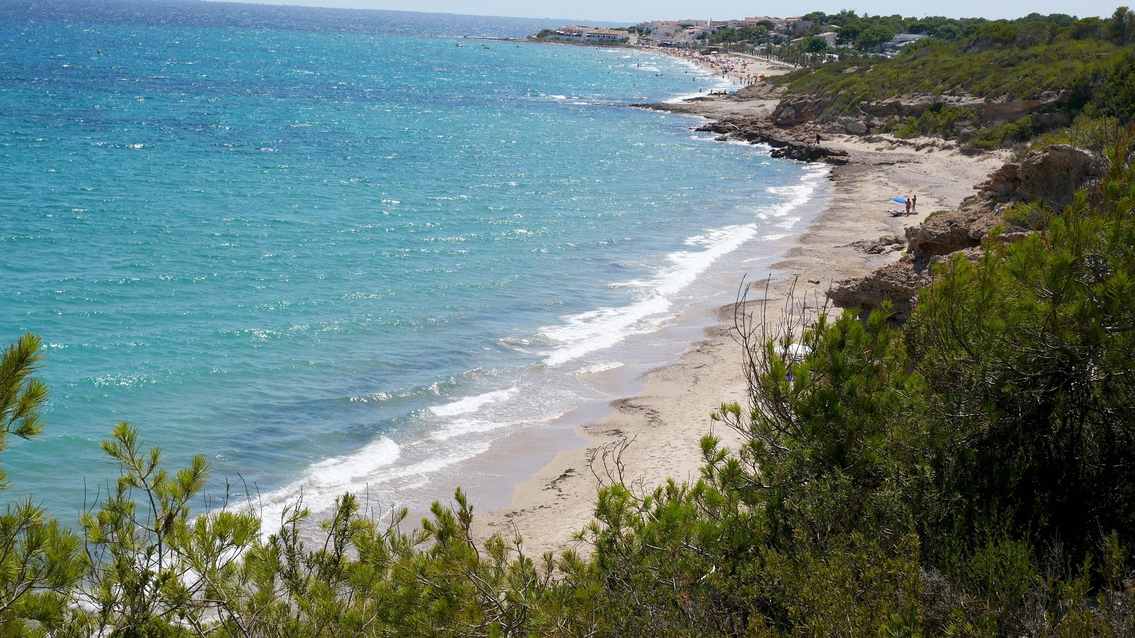 Photo de Plage d'Almadrava avec l'eau bleu-vert de surface