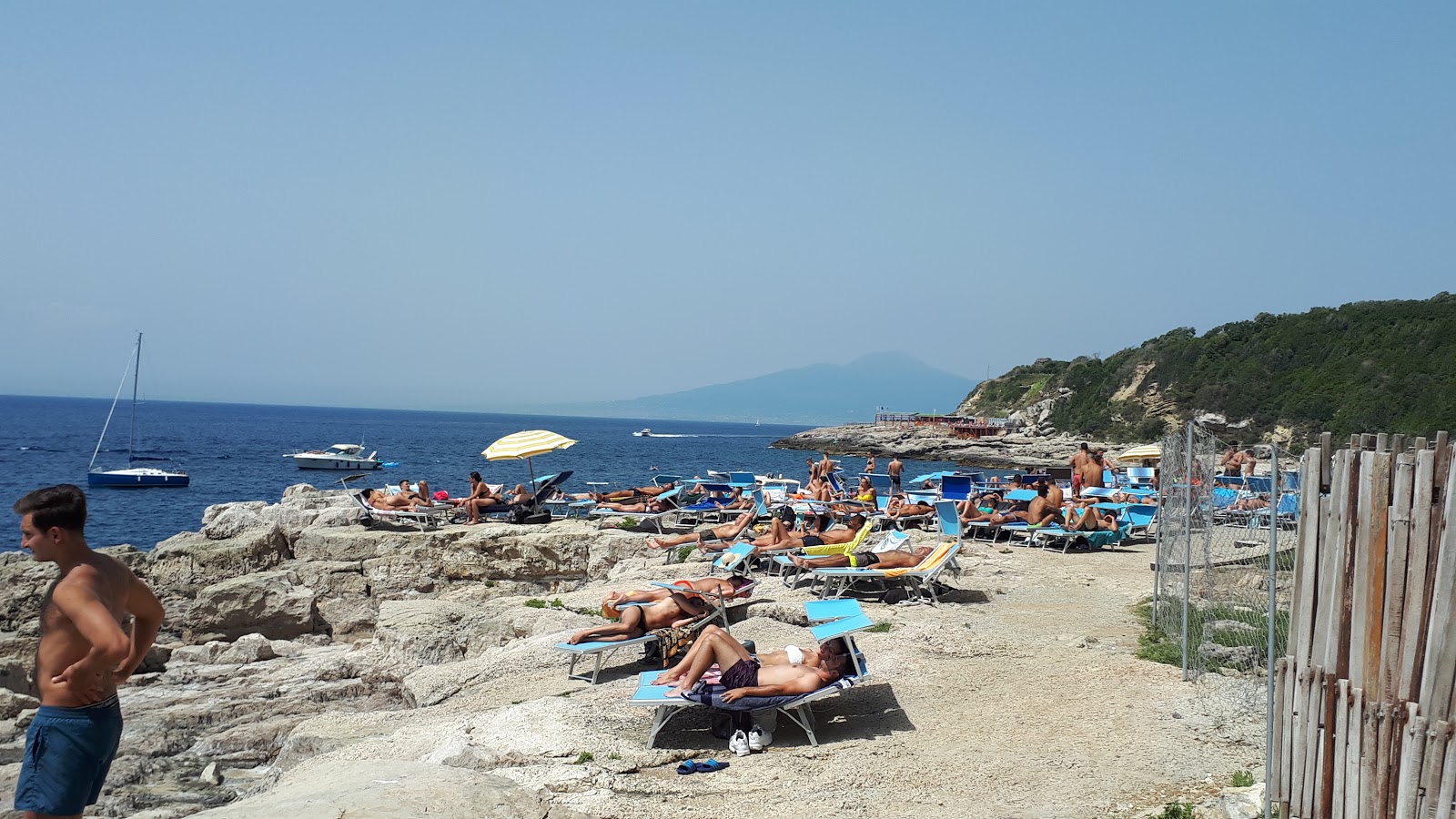 Foto von Spiaggia della Pignatella von Klippen umgeben