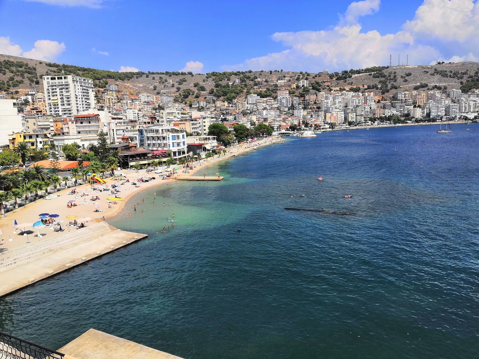 Zdjęcie Saranda beach z powierzchnią małe beżowe kamyki