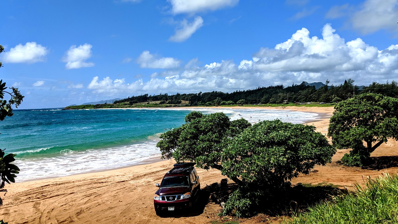 Foto von Kealia Beach von Klippen umgeben