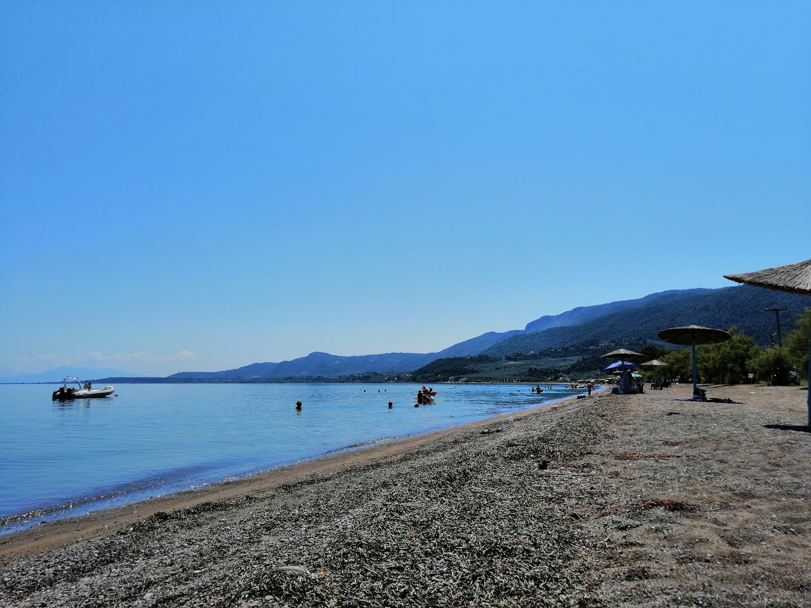 Loggos beach'in fotoğrafı kahverengi çakıl yüzey ile