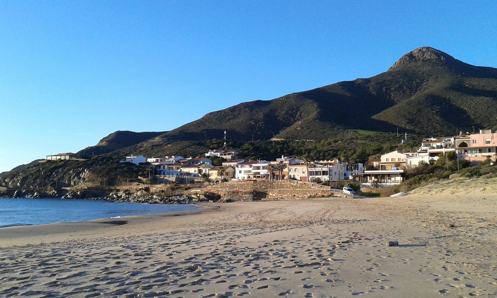 Foto von Spiaggia di Portixeddu von Klippen umgeben