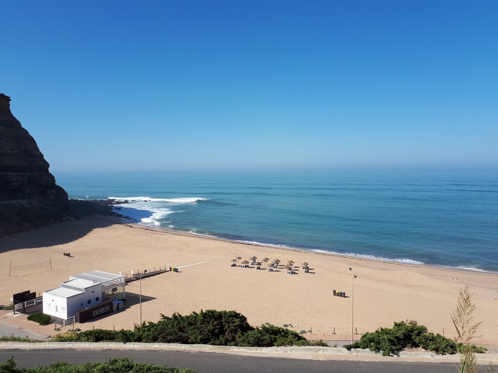 Foto av Praia da Calada omgiven av klippor