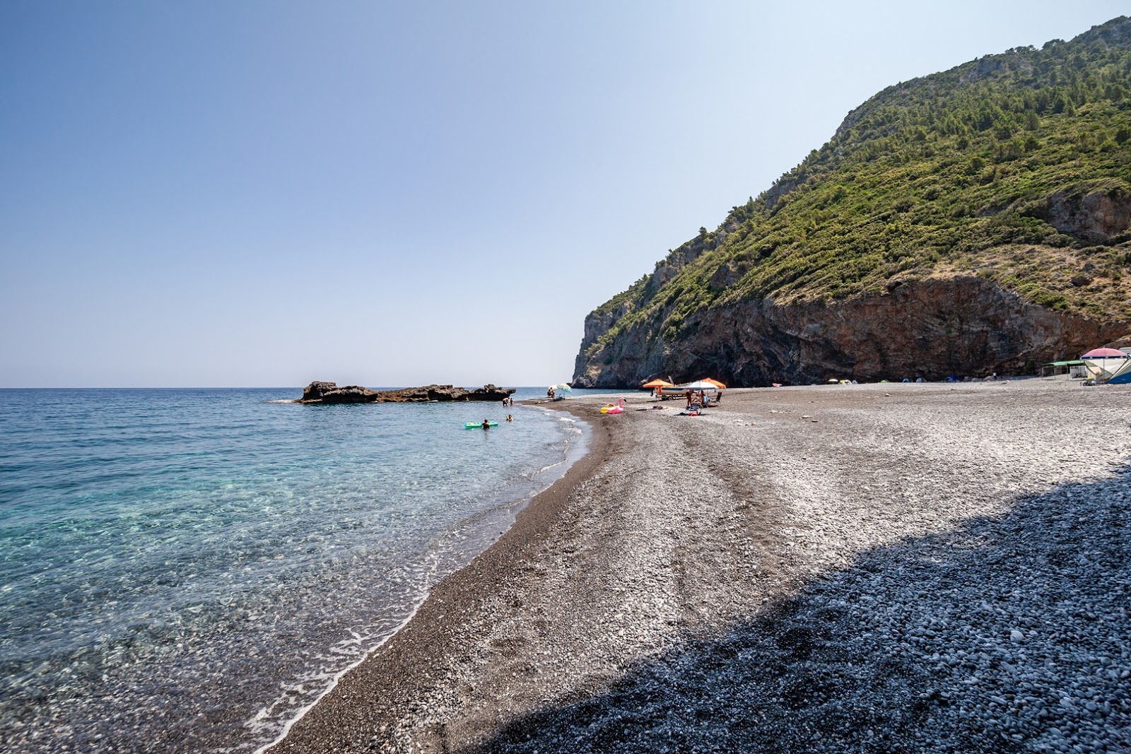 Foto av Petali Stranden med harmaa hiekka ja kivi yta
