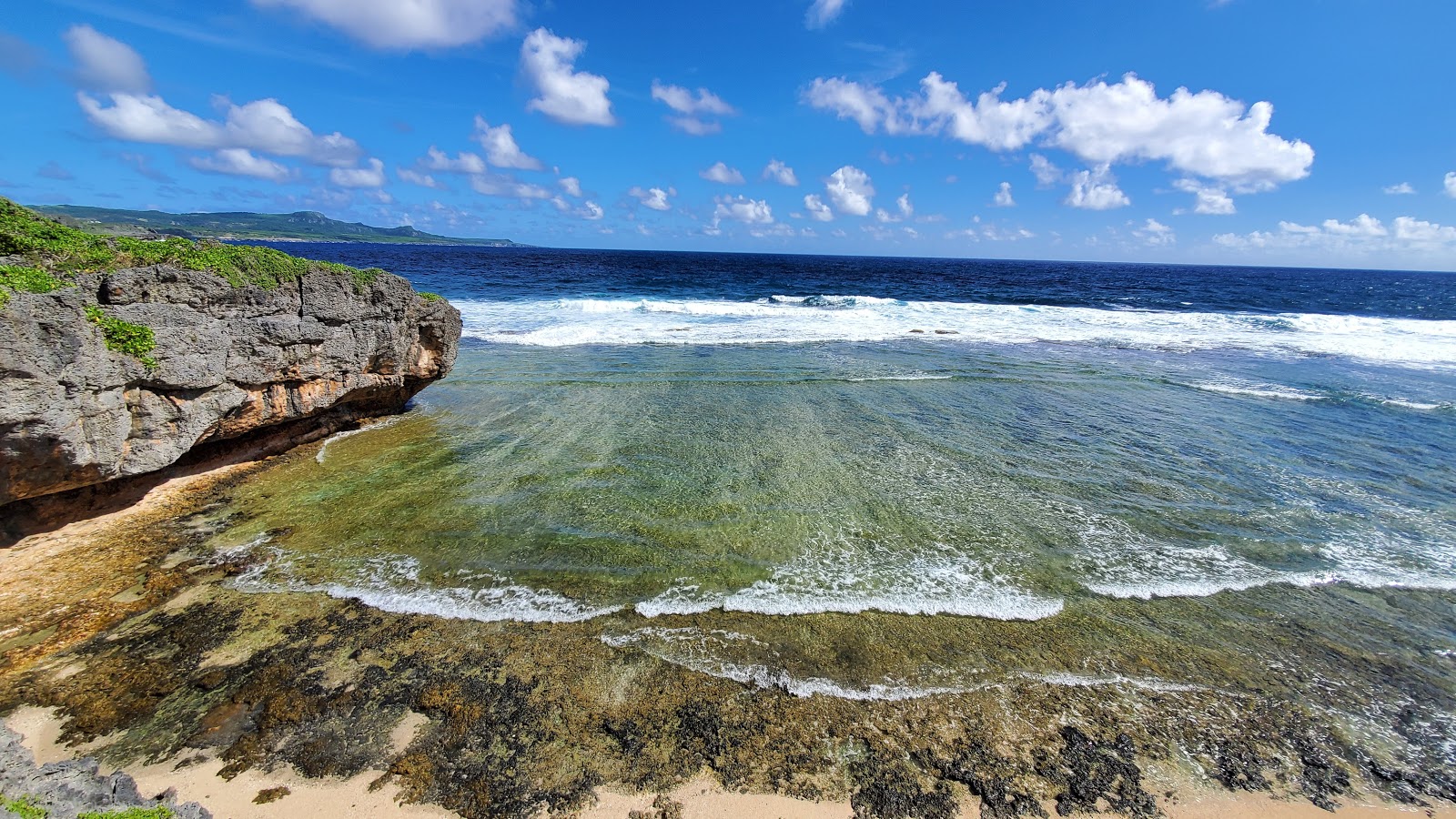 Φωτογραφία του Marine Beach με μπεζ άμμος και βράχοι επιφάνεια