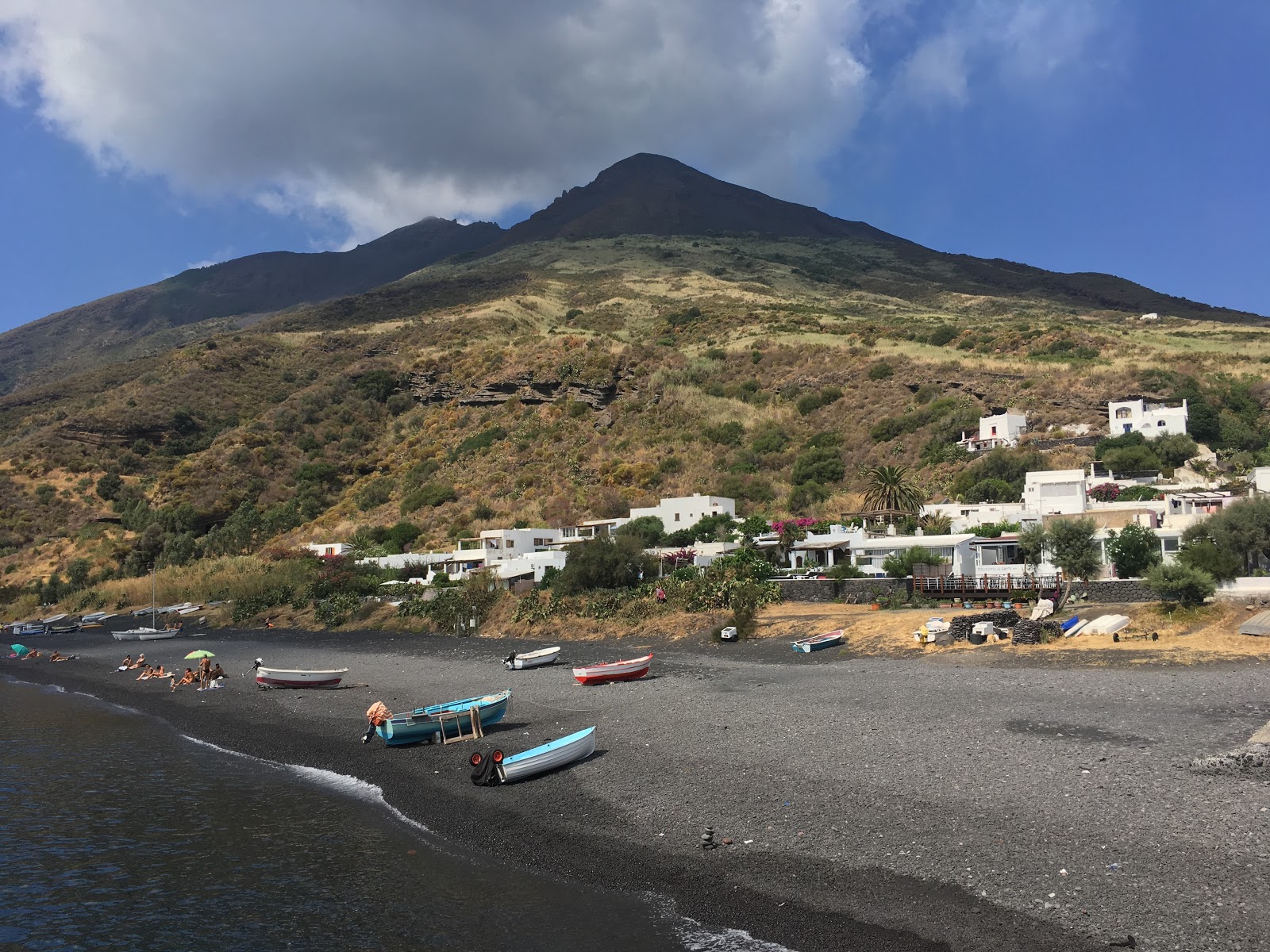 Scari beach'in fotoğrafı siyah kum yüzey ile