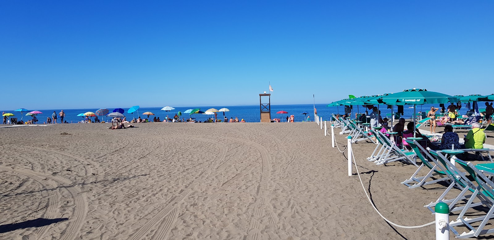 Photo de Marina di Castagneto avec sable brun de surface