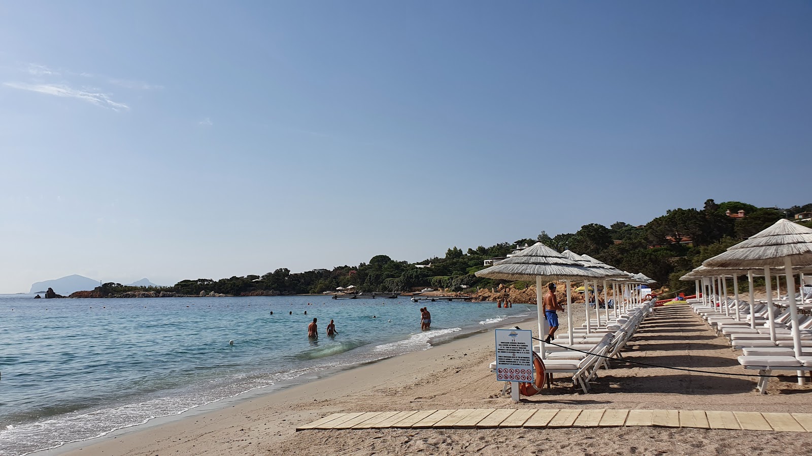 Valokuva Spiaggia Del Romazzinoista. pinnalla sininen puhdas vesi:n kanssa