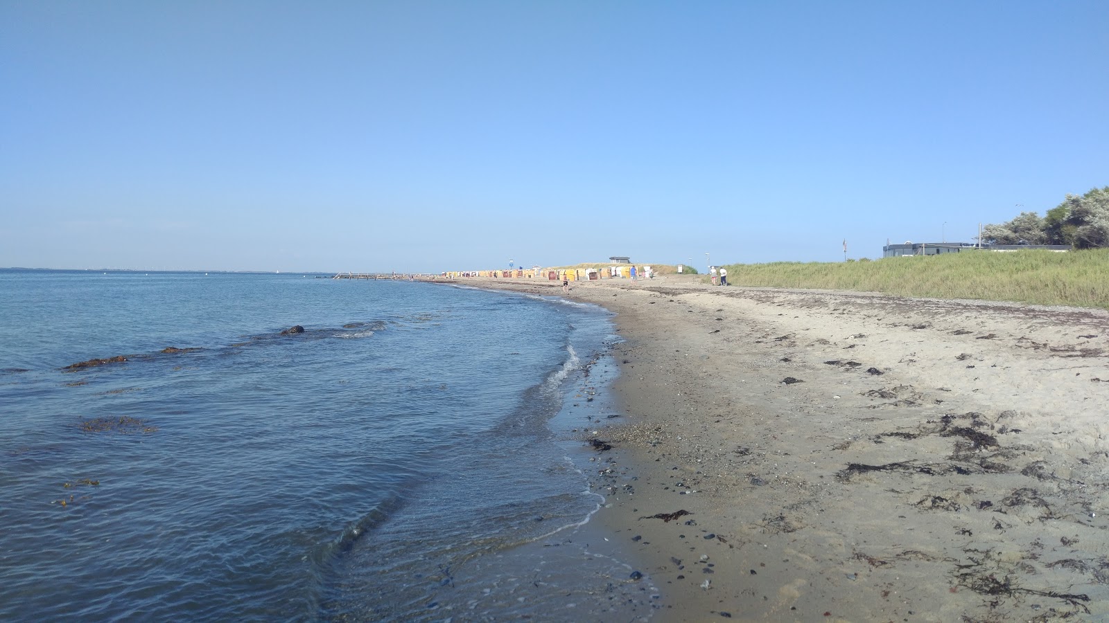 Fotografija Strandkorbvermietung z siv pesek površino