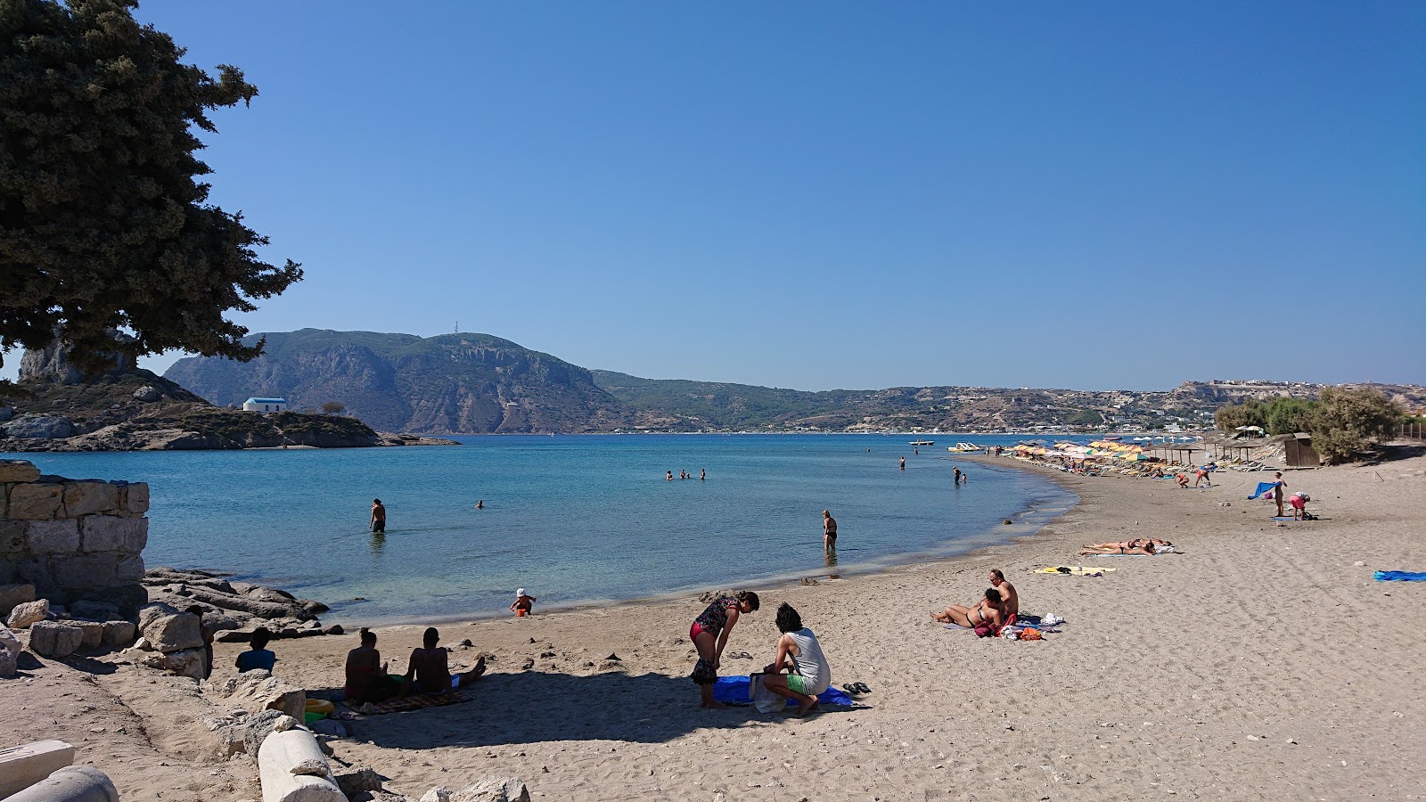 Foto van Agios Stefanos met zand met kiezelstenen oppervlakte