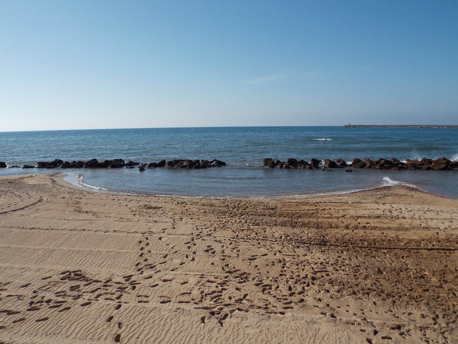 Fotografie cu Baia Del Conte cu o suprafață de nisip strălucitor