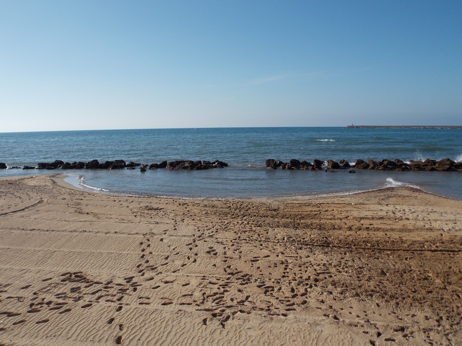 Foto van Baia Del Conte met beige zand oppervlakte