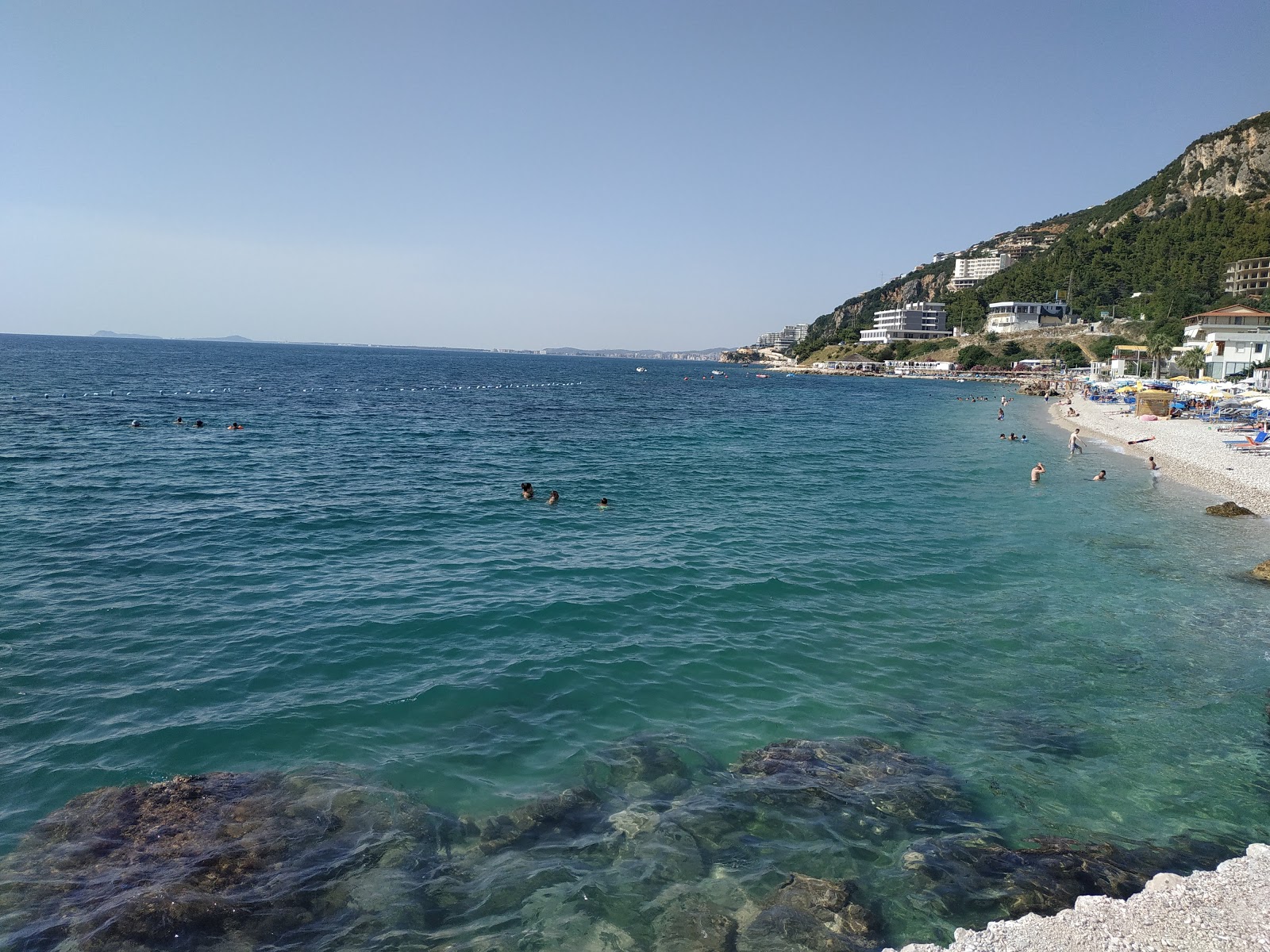 Photo of Sunny beach backed by cliffs