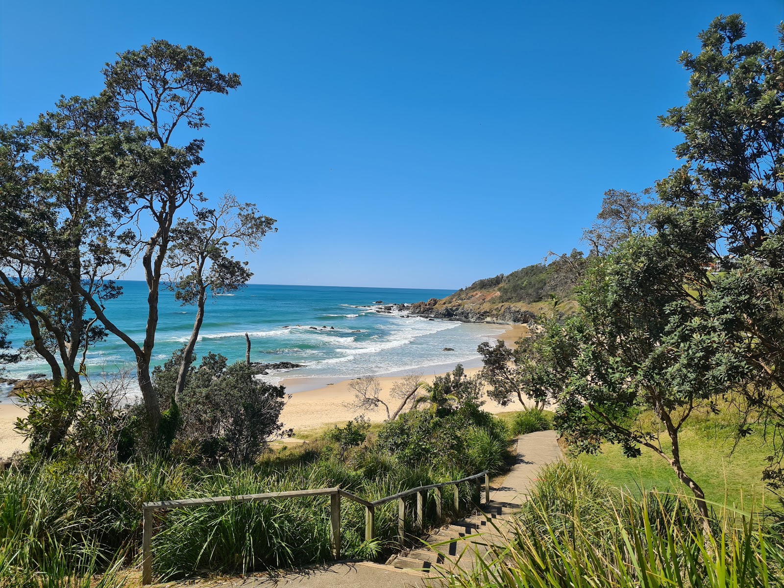Foto di Oxley Beach con una superficie del sabbia beige
