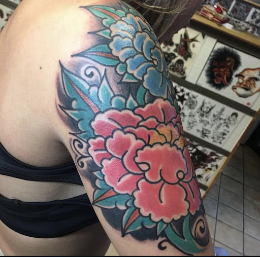 Explore purple flower tattoo ideas, creative tattoo ideas in Columbia, available at -Born Again Tattoo- New Tattoos, Cover-Ups, Repairs, & Restorations Made Daily