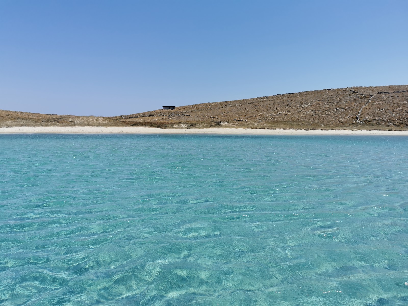Foto di Skinos beach con una superficie del sabbia con ciottolame