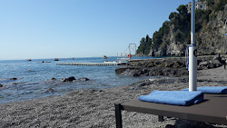 Foto von Spiaggia di Giardini del Fuenti umgeben von Bergen