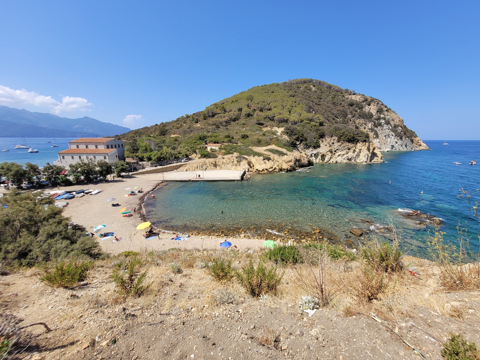 Foto van Spiaggia di Enfola ondersteund door kliffen