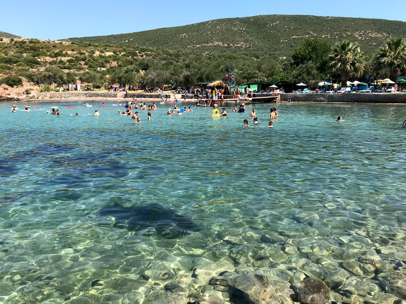 Foto di Korsan beach con una superficie del sabbia marrone e rocce