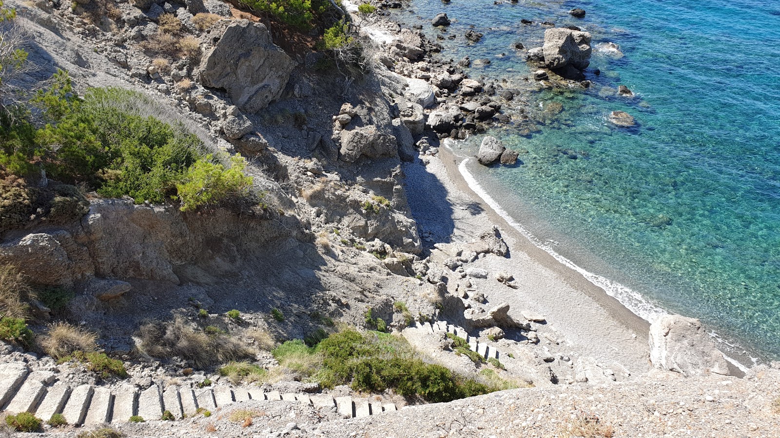 Valokuva Giorgaki beachista. pinnalla harmaa kivi:n kanssa