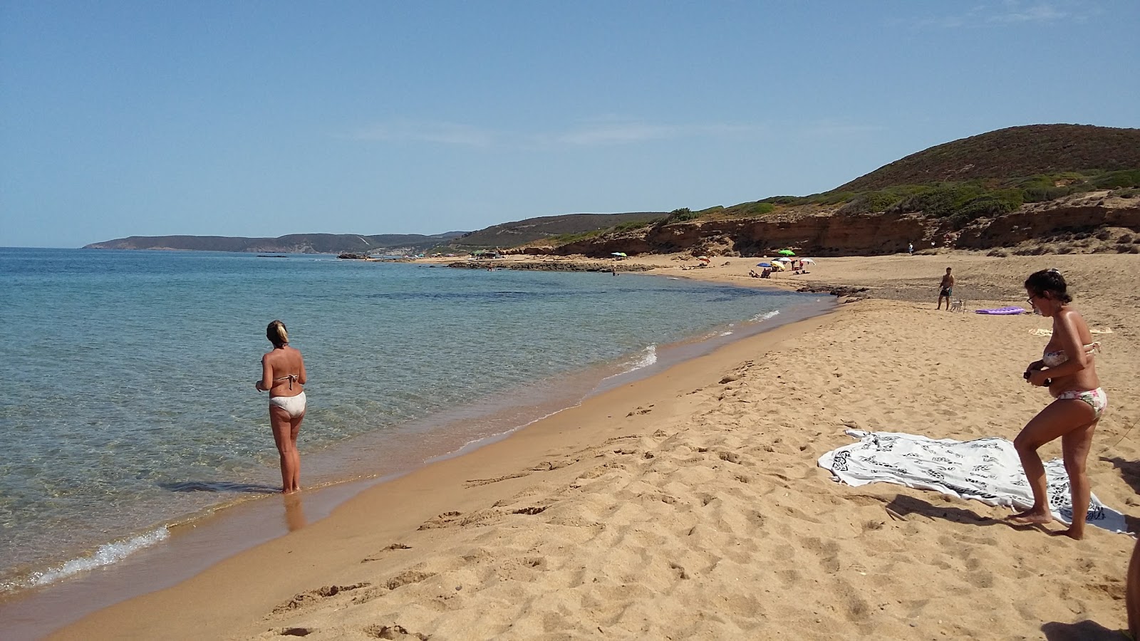 Foto von Spiaggia S'Acquedda von Klippen umgeben