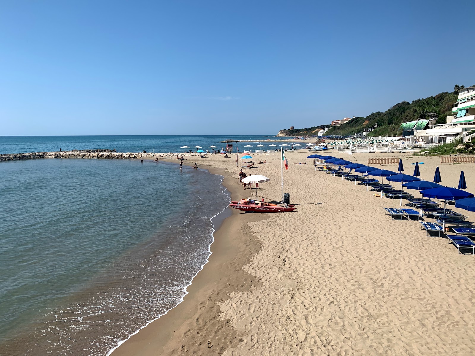 Photo de Lido delle Sirene avec sable brun de surface