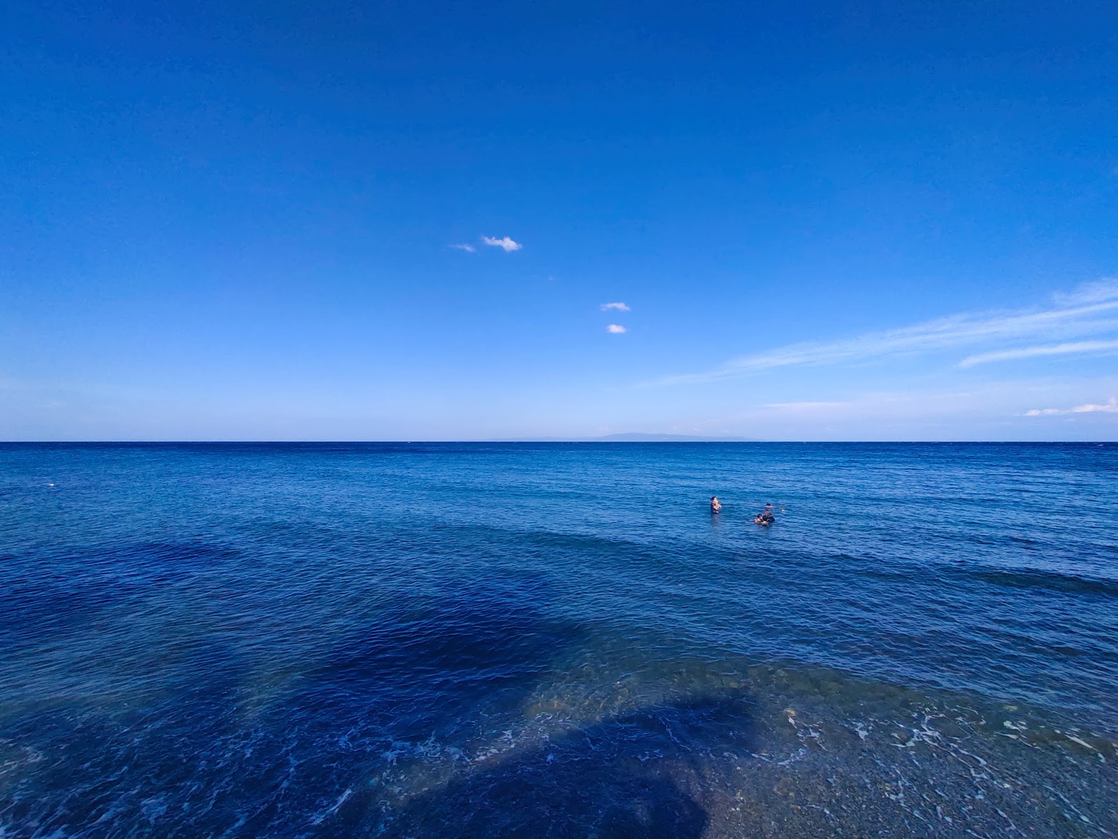 Fotografie cu Treeba Beach cu o suprafață de nisip gri