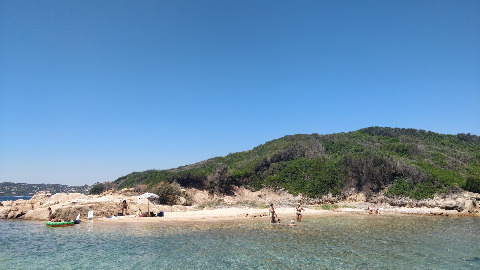 Fotografie cu Cala Rocciosa II cu o suprafață de nisip beige și pietricele