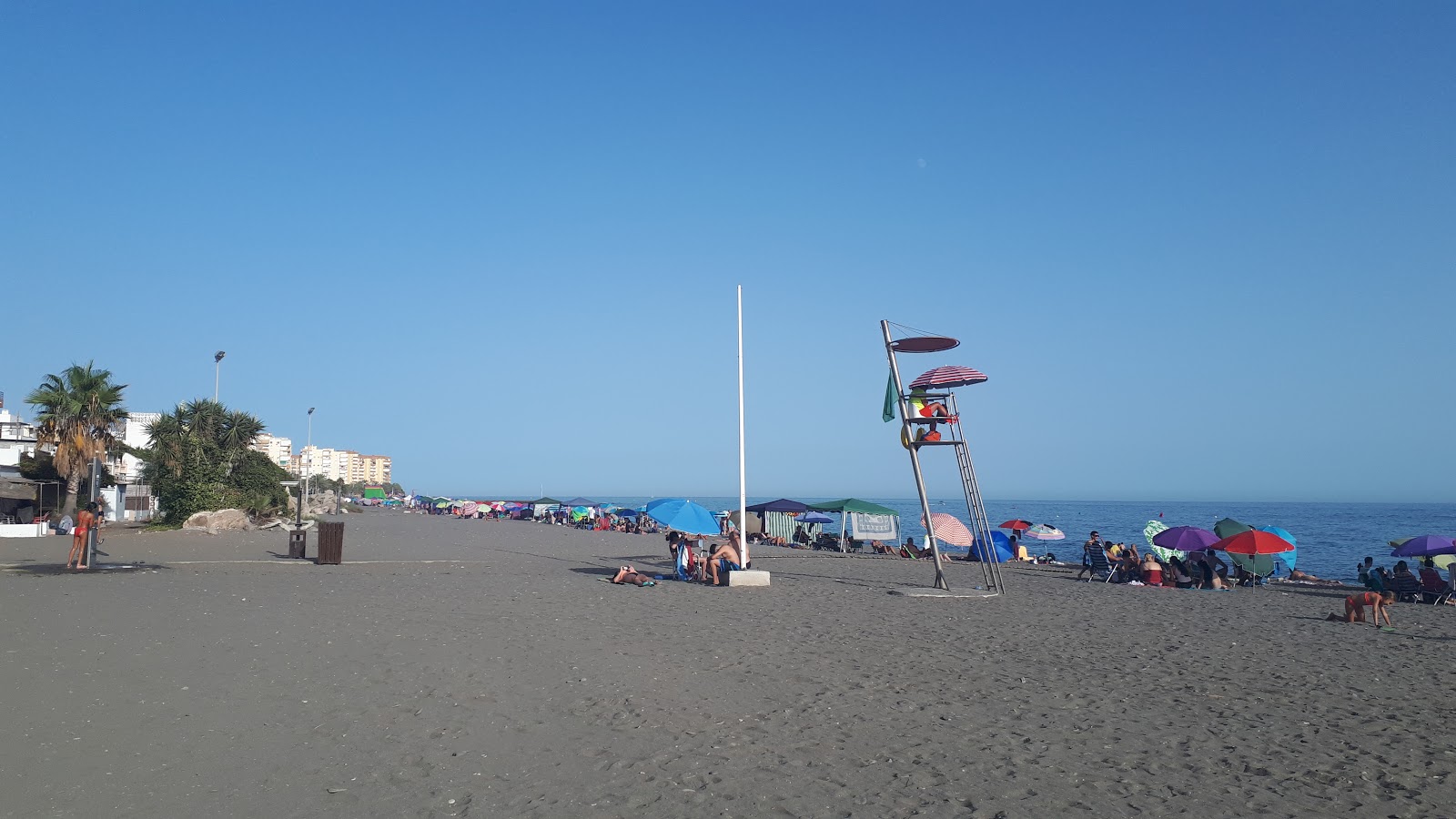 Foto von Playa Caleta de Velez mit grauer sand Oberfläche