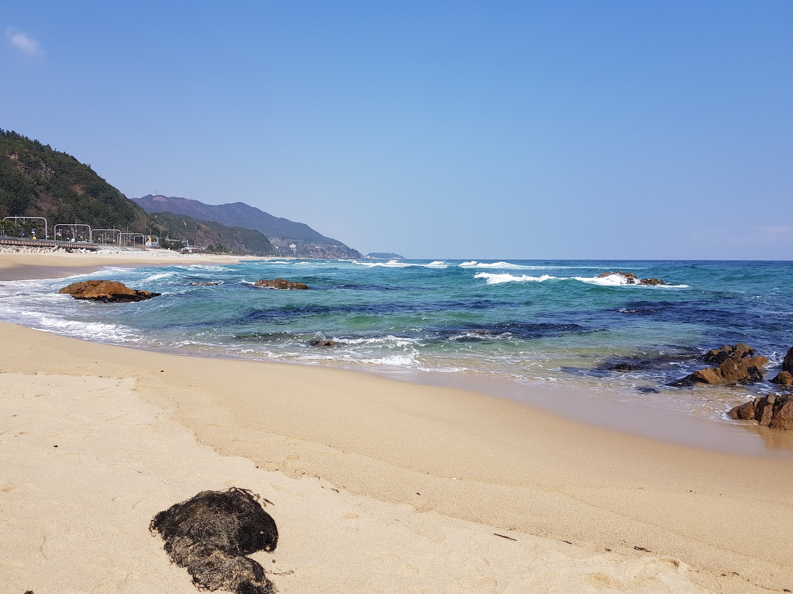 Deungmyeong Beach的照片 带有碧绿色纯水表面