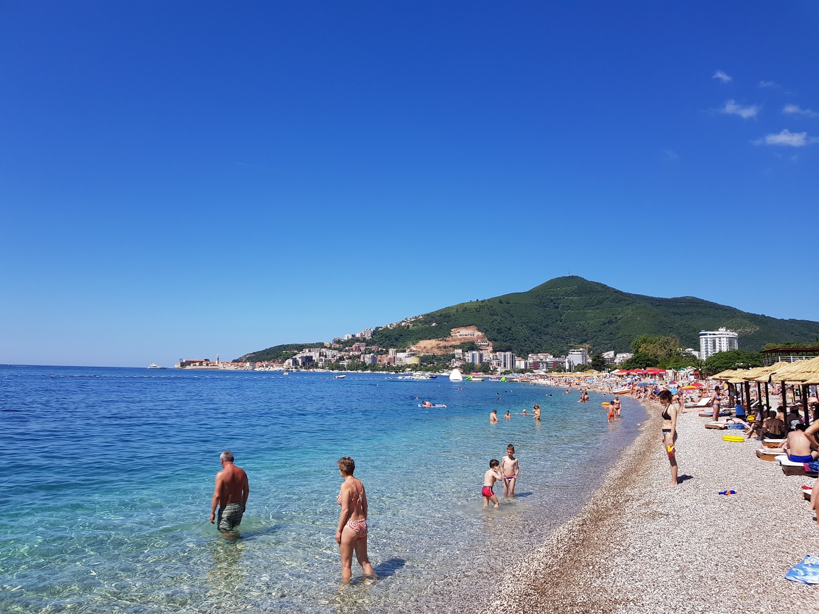 Foto av Budva Stranden med små beige småsten yta