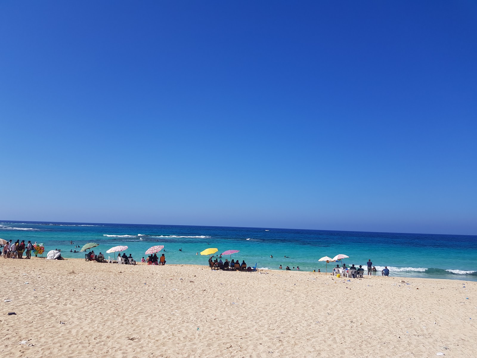 Valokuva Minaa Alhasheesh beachista. pinnalla turkoosi puhdas vesi:n kanssa