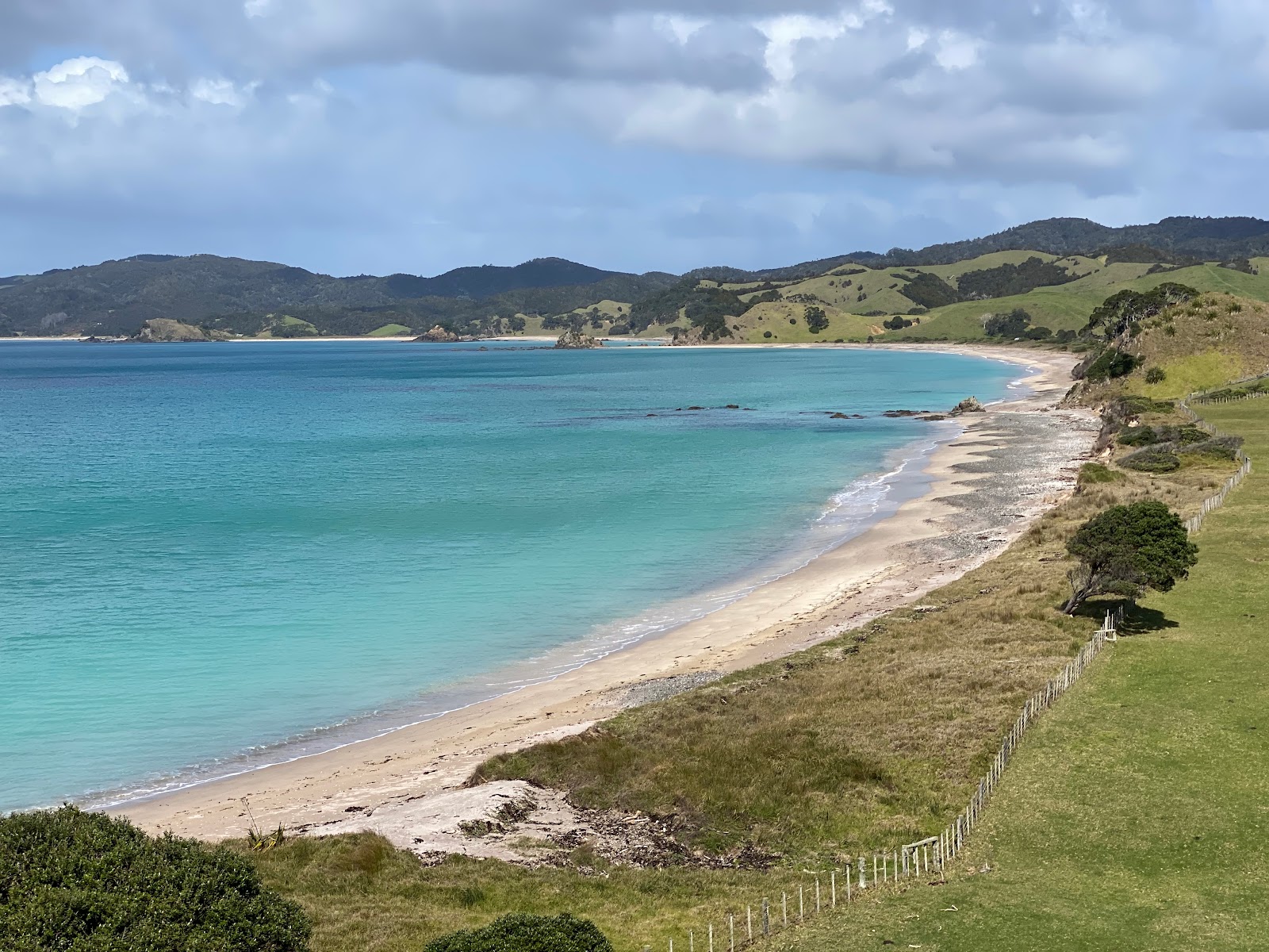 Foto av Okupe Beach med kevyt hiekka ja kivi yta