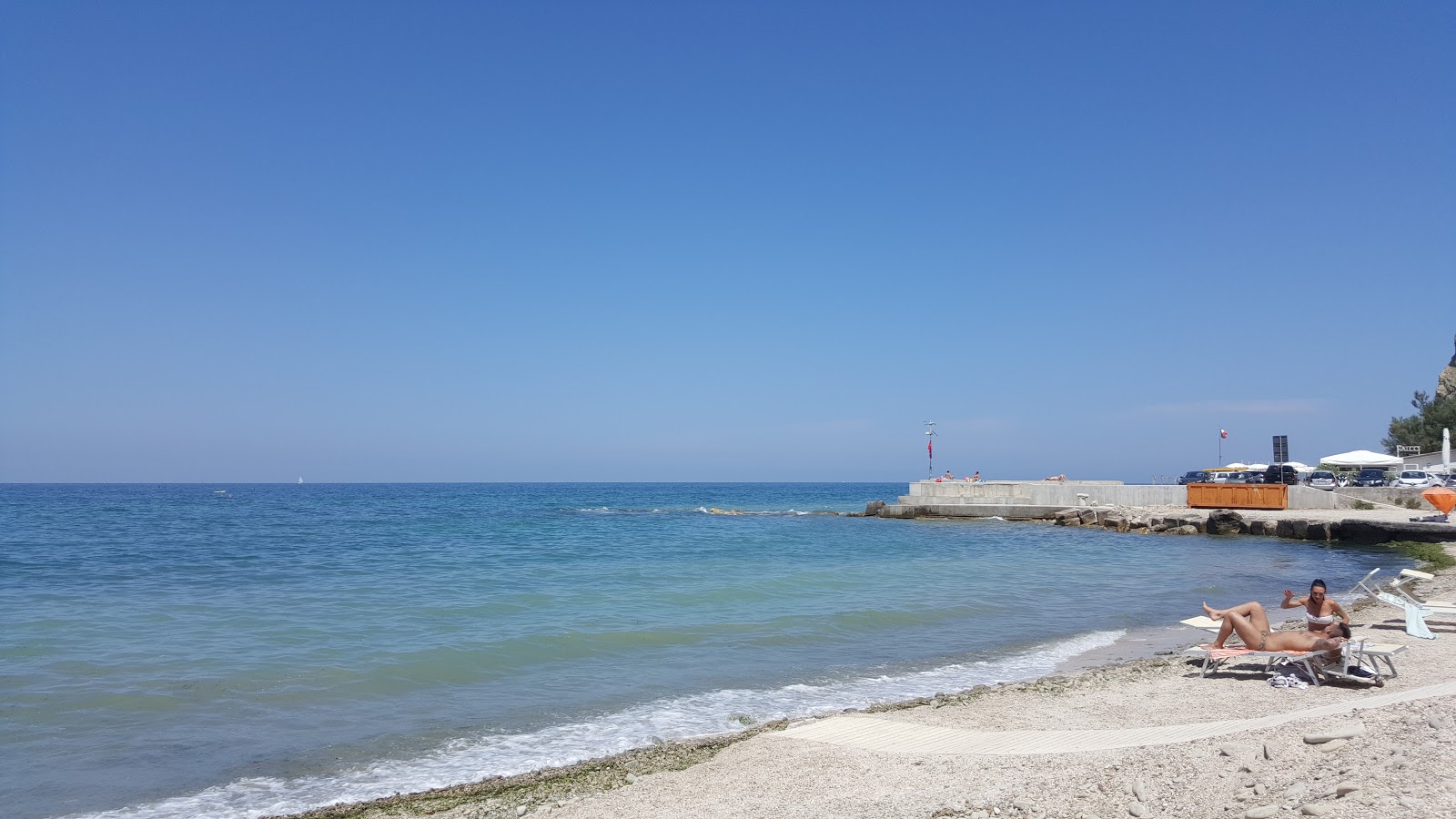 Valokuva Spiaggia Baia Vallugolaista. pinnalla turkoosi puhdas vesi:n kanssa