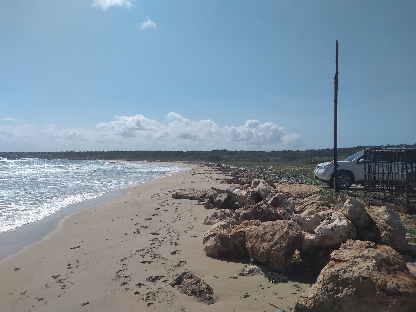Fotografija Genesis Beach z svetel pesek in kamni površino