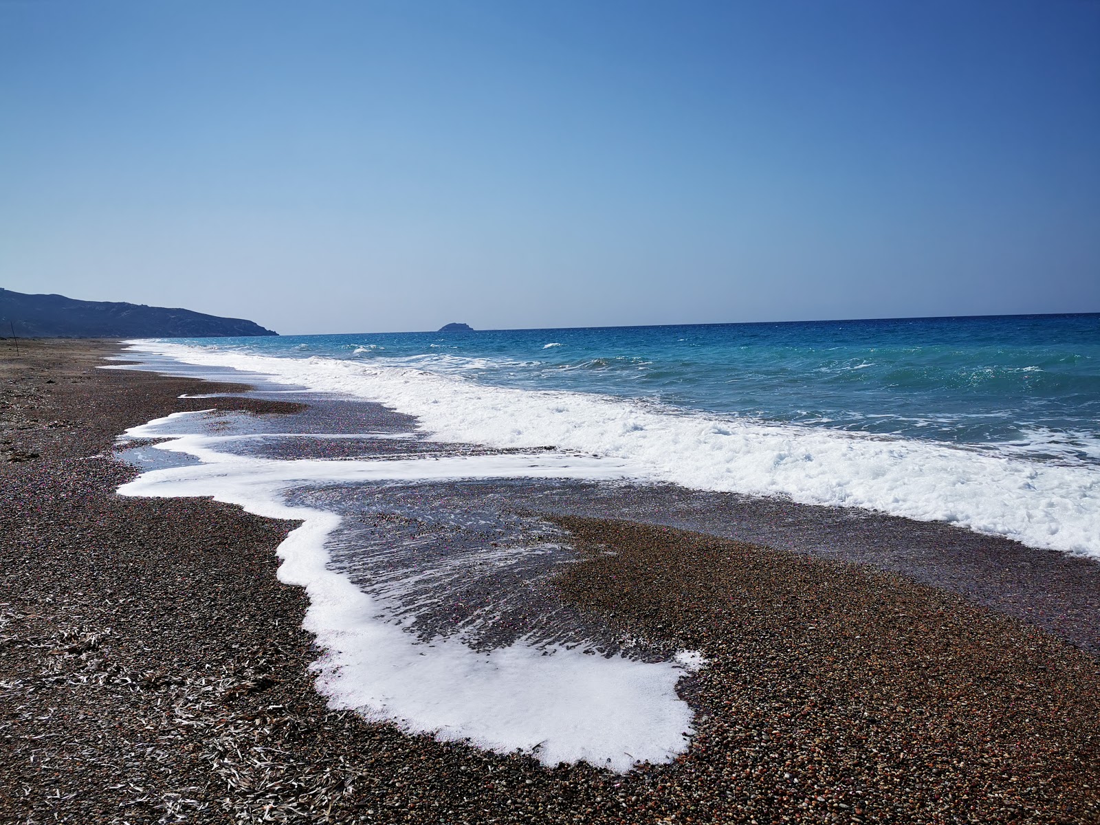 Foto de Kouloura Beach com água azul escura superfície