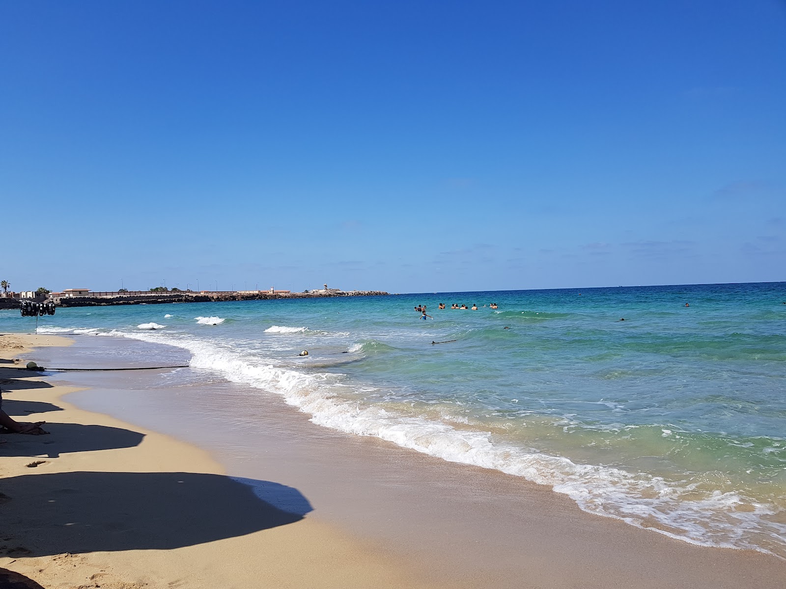 Fotografie cu Alexandria Corniche cu o suprafață de nisip fin alb