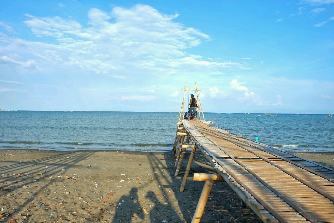 Photo de Muara Lungkak Beach avec l'eau turquoise de surface