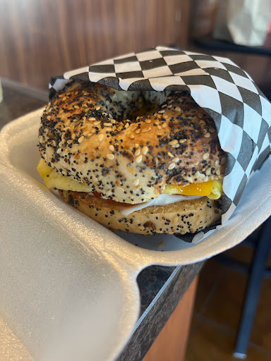 Bagel breakfast with egg, cheese, tomato, and mayo.
