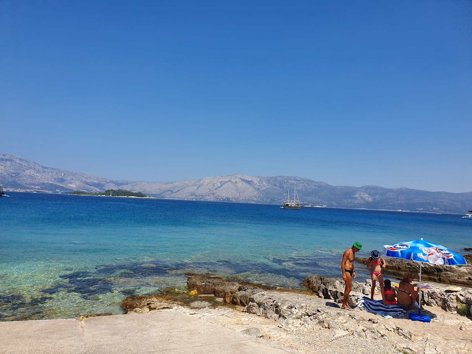 Fotografie cu Lumbarda beach cu o suprafață de nisip gri și pietricele